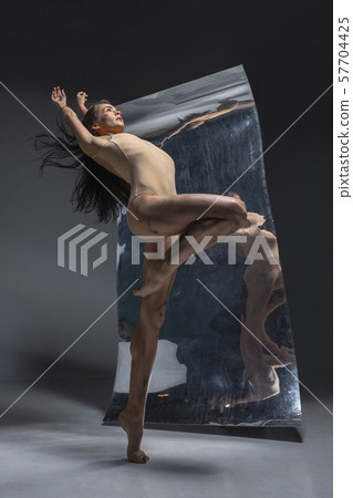 Young and stylish modern ballet dancer on grey background Young and stylish modern ballet dancer on grey background 57704425