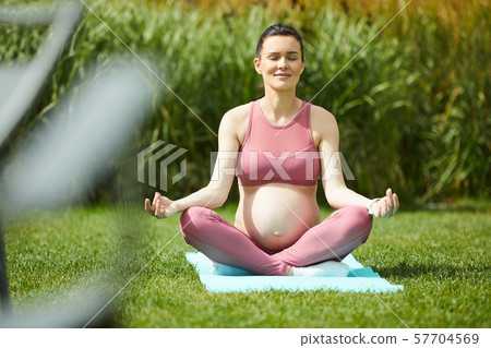 Pregnant woman doing yoga Pregnant woman doing yoga 57704569