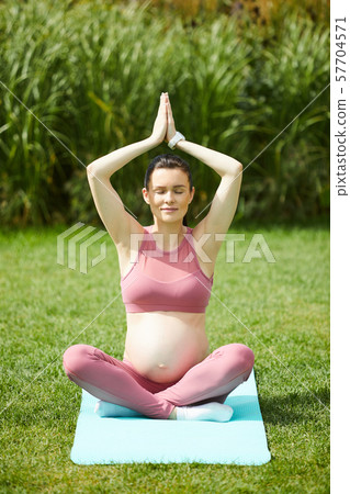 Pregnant woman relaxing outdoors Pregnant woman relaxing outdoors 57704571