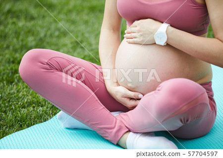 Pregnant woman exercising in the park Pregnant woman exercising in the park 57704597