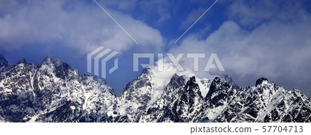 Snowy rocks in clouds at sun winter day Snowy rocks in clouds at sun winter day 57704713