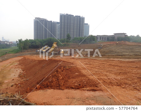 Heavy machinery doing the earthwork and site clearing at the construction site. Heavy machinery doing the earthwork and site clearing at the construction site. 57704764