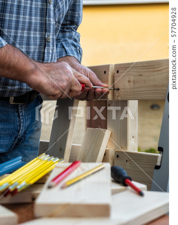 Craftsman at work on wooden boards. 57704928