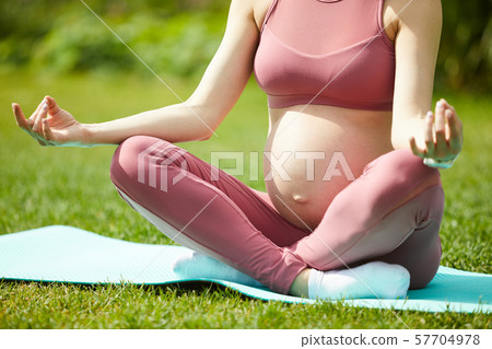 Pregnant woman meditating outdoors 57704978