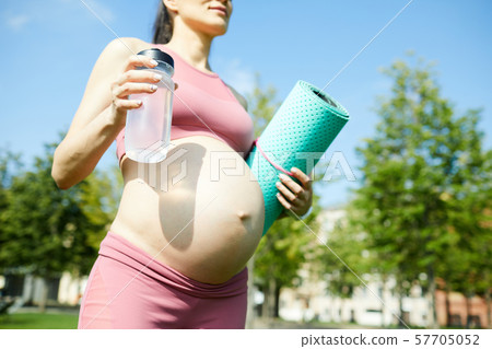 Pregnant woman training outdoors 57705052