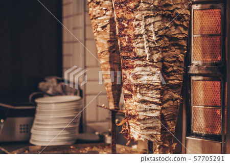 Doner kebab - dish in Middle Eastern cuisine. Roasted meat for shawarma in the street cafe or Doner kebab - dish in Middle Eastern cuisine. Roasted meat for shawarma in the street cafe or 57705291