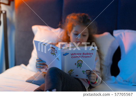 Cute little girl reading book before sleeping Cute little girl reading book before sleeping 57705567