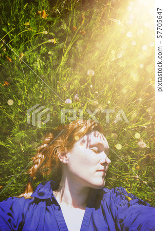 40 years old woman lying on green grass in park 57705647