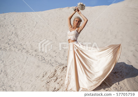 Beautiful bride is wearing fashion dress in the great desert in Dubai. 57705759