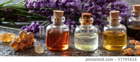 Panoramic header of essential oil bottles with frankincense, benzoin and lavender flowers 57705818