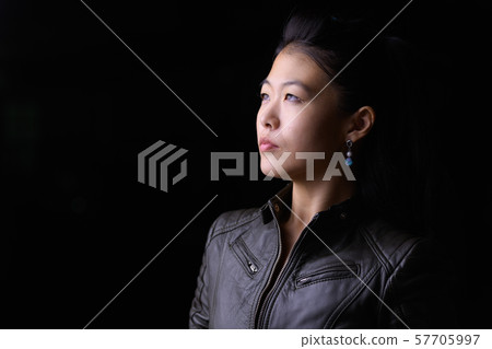Face of beautiful Asian rebellious woman thinking outdoors at night 57705997