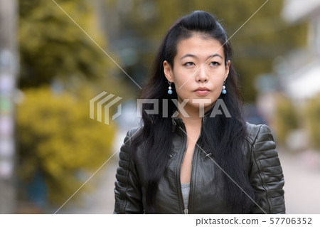 Face of beautiful Asian rebellious woman thinking outdoors 57706352