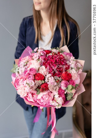 Pink peonies and red hydrangea. Beautiful bouquet of mixed flowers in woman hand. Floral shop 57708963