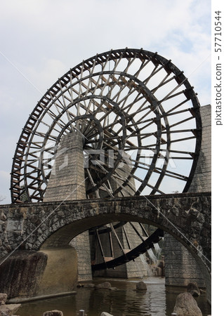 Giant water wheel and stone arch bridge 57710544
