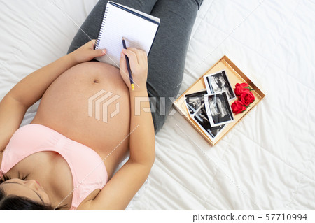 Happy pregnant woman and expecting baby at home. Happy pregnant woman and expecting baby at home. 57710994