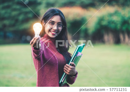 Creative young woman hold shinning light bulb. 57711231