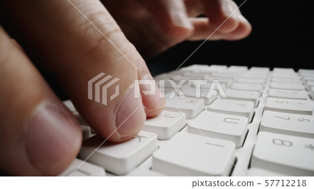 Close-up soft-focus finger typing on keyboard. 57712218