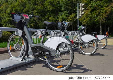 Bicycles for rent are on a bicycle parking lot on a city street 57715587
