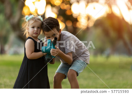 Cute little children paying with green appliance 57715593