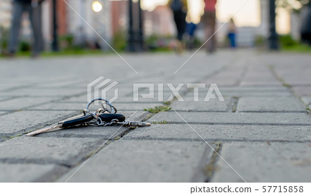 The lost bunch of keys, lies on the asphalted sidewalk 57715858