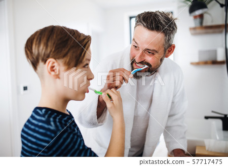Mature father with small son in the bathroom in the morning, brushing teeth. Mature father with small son in the bathroom in the morning, brushing teeth. 57717475