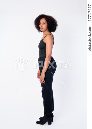 Full body shot profile view of young beautiful African woman looking at camera Full body shot profile view of young beautiful African woman looking at camera 57717477