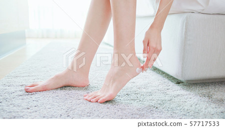 woman apply lotion with foot 57717533