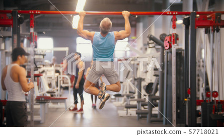 Men training in the gym - pulling up on the bar - drinking water Men training in the gym - pulling up on the bar - drinking water 57718021