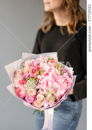 Pink color. Beautiful bouquet of mixed flowers in womans hands. the work of the florist at a flower 57718562