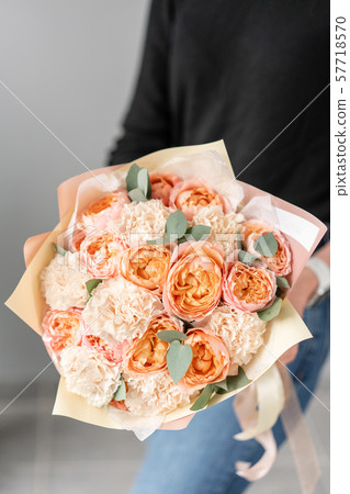 White and peach color. Beautiful bouquet of mixed flowers in womans hands. the work of the florist 57718570