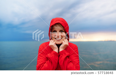 Young woman standing outdoors on beach at dusk., looking at camera. Young woman standing outdoors on beach at dusk., looking at camera. 57718648
