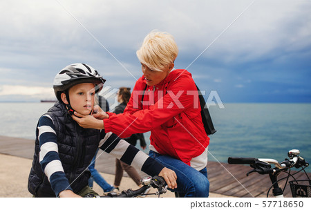 Mother and small son with bicycles outdoors standing on beach. Mother and small son with bicycles outdoors standing on beach. 57718650