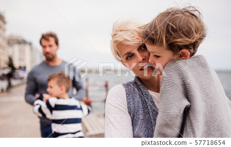 Young family with two small children outdoors on beach. 57718654