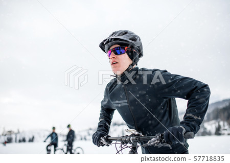 Side view of mountain biker riding in snow outdoors in winter nature. 57718835