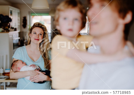 Young parents with newborn baby and small toddler son at home. Young parents with newborn baby and small toddler son at home. 57718985