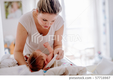 A beautiful young mother looking after a newborn baby at home. 57718987