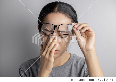 Women hold glasses and suffer from eye pain. Women hold glasses and suffer from eye pain. 57719074