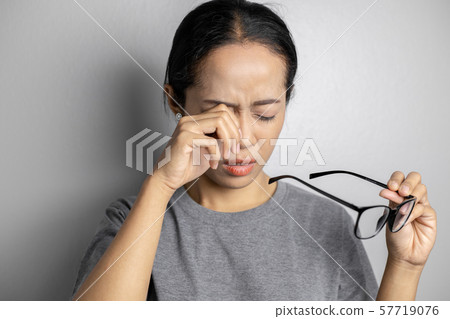 Women hold glasses and suffer from eye pain. Women hold glasses and suffer from eye pain. 57719076
