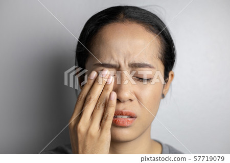 Woman suffering from strong eye pain. Woman suffering from strong eye pain. 57719079