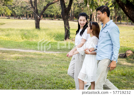 Parents and children walking hand in hand in the Parents and children walking hand in hand in the 57719232