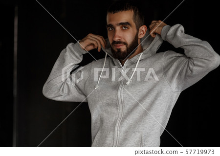 Young stylish man with a beard with a hood Young stylish man with a beard with a hood 57719973