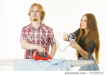 Woman controling man to do ironing Woman controling man to do ironing 57720715