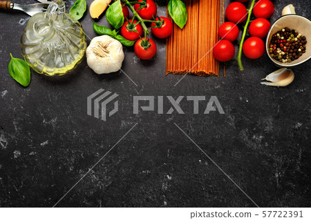 Top view on dry pasta and fresh cherry tomatoes on dark black background Top view on dry pasta and fresh cherry tomatoes on dark black background 57722391