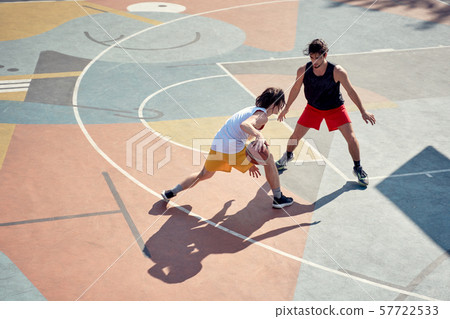 Top view image of two young athletes men playing basketball on playground in morning. Top view image of two young athletes men playing basketball on playground in morning. 57722533