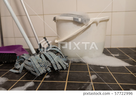 Broom and mop with bucket, in white and black tile background. Broom and mop with bucket, in white and black tile background. 57722996