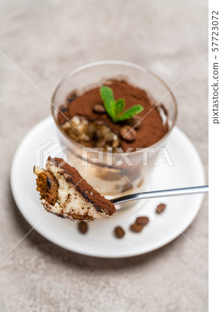 Portion of Classic tiramisu dessert in a glass cup on concrete background 57723072