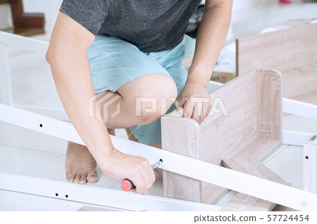 Senior man assembling furniture at home, a new 57724454
