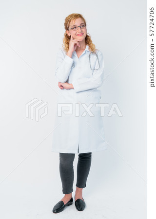Full body shot of happy blonde woman doctor thinking and looking up Full body shot of happy blonde woman doctor thinking and looking up 57724706