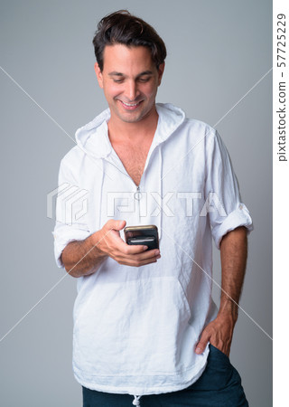 Portrait of happy handsome Hispanic man using phone 57725229