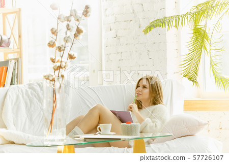 Beautiful young woman relaxing at home, comfort and calm 57726107